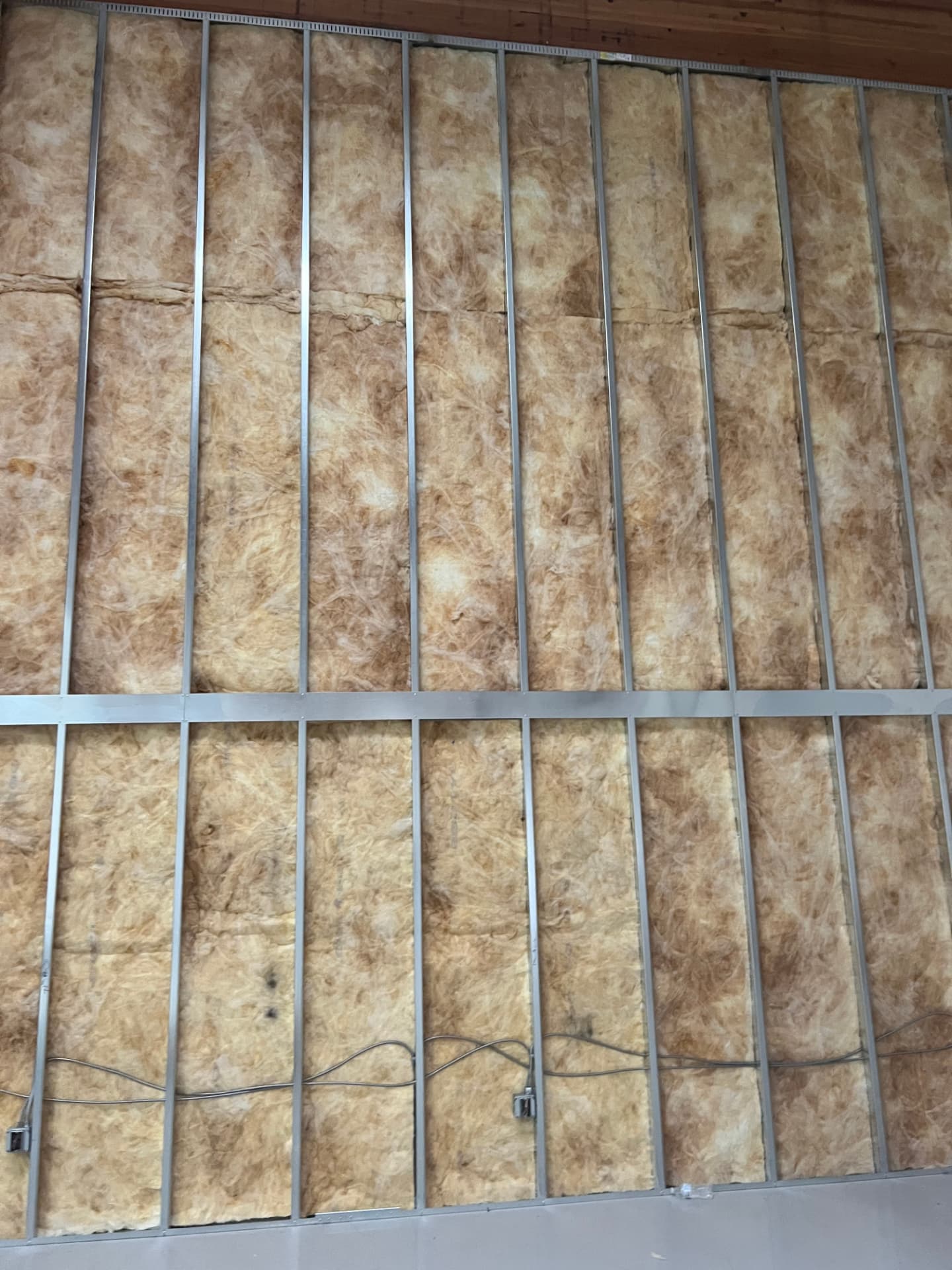 Metal stud framing with batt insulation installed before drywall on an interior partition